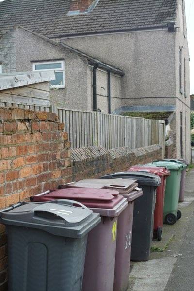 Worn, dingy residential trash bins before cleaning